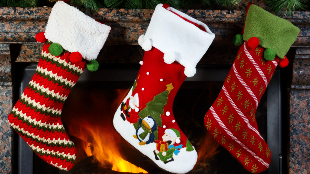Three Christmas Stockings Hung On A Fireplace