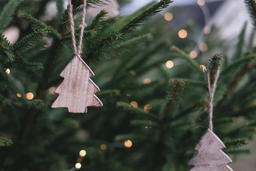 Small Wooden Christmas Tree Decorations Hanging On A Christmas Tree